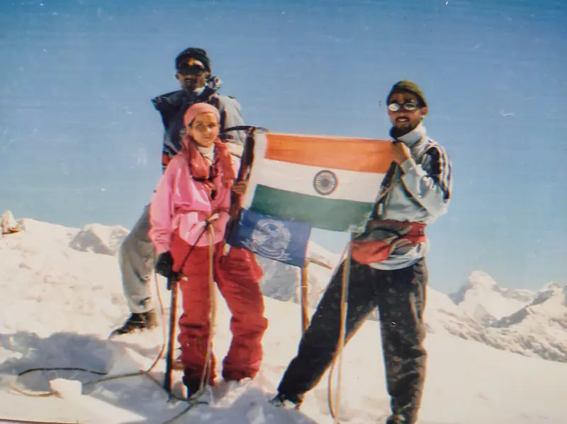 Three climbers with the Indian flag on a Himalayan summit